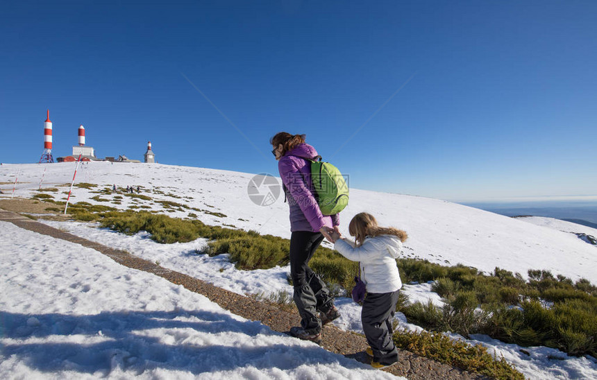 母亲在西班牙马德里纳瓦塞拉达雪山高峰会与三岁小孩一起徒步远足的母亲相握手的寒冬图片