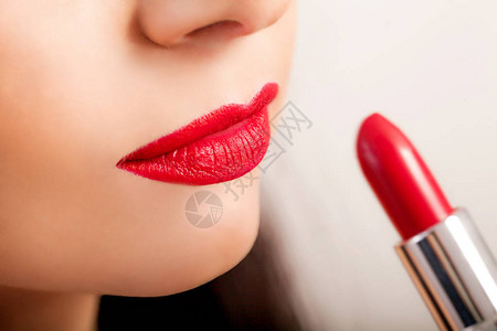 红唇膏女人脸的特写镜头与明亮的红色哑光唇膏在全唇上美容化妆品图片