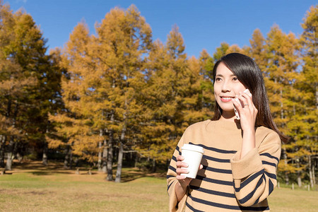 妇女与手机交谈在秋季图片