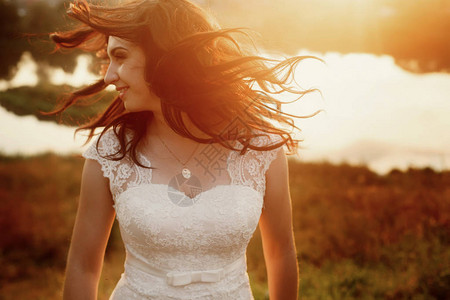 美丽的黑发新娘穿着优雅的白色婚纱和金项链图片