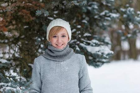 穿着白色帽子的漂亮女孩和冬雪森林里的手套图片