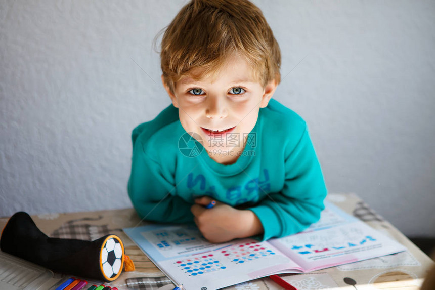 在家做功课时可爱快乐的学校男孩的肖像图片