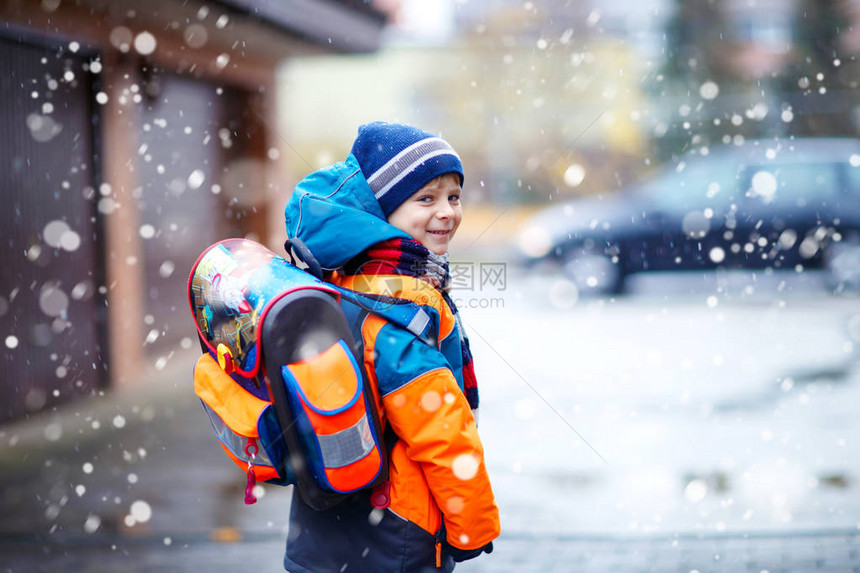 小学生在降雪期间步行去学校的小学男孩图片