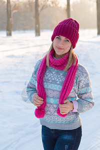 穿着粉红色帽子和冬季森林围巾的年图片