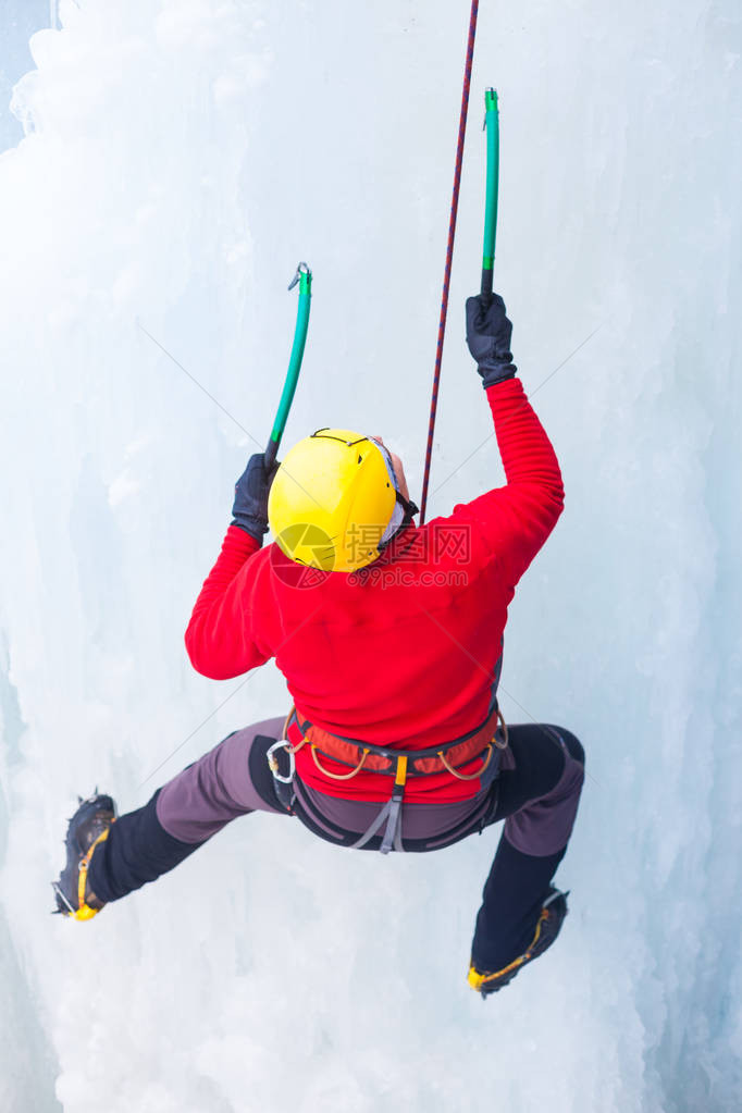 一名年轻的登山者在攀冰和寒冷天气下冬季体图片
