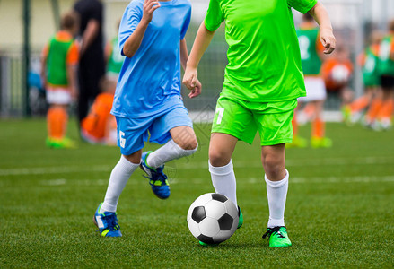 青年足球运动员男孩在球场上踢足球儿图片