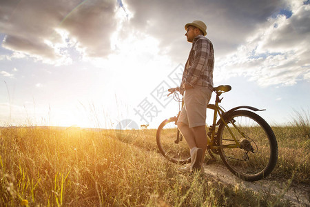 在美丽的日落上骑着球场骑着自行车图片