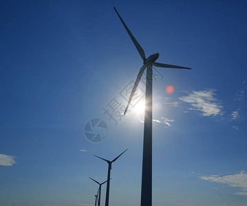 蓝天白云上绿草上的风力涡轮机背景图片