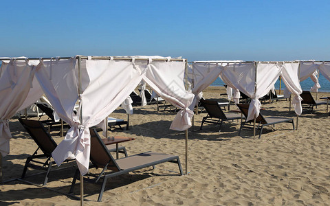 沙滩上有窗帘的甲板椅子以躲避炎图片