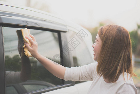 亚洲妇女用超细纤维布洗车窗图片