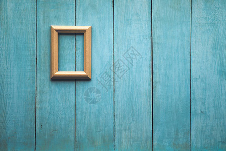 蓝色木墙上的旧木相框图片