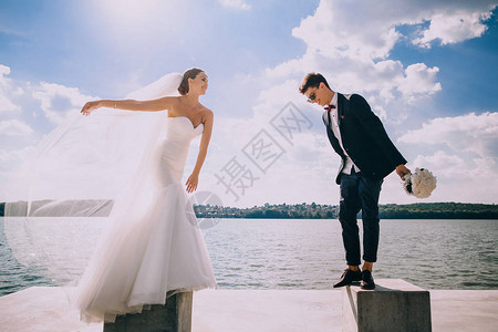 美丽的婚礼快乐的新郎和新娘站在蓝天和图片