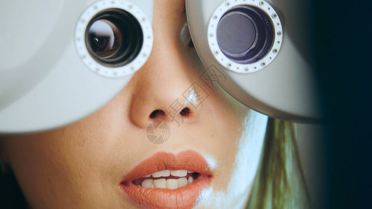 红嘴唇的年轻女子在检查医疗中心现代设备的眼睛图片