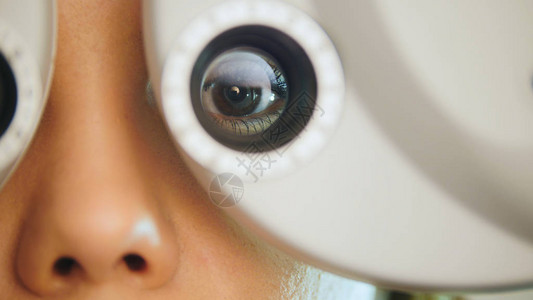 红唇年轻女检查医疗中心现代设备的眼睛图片