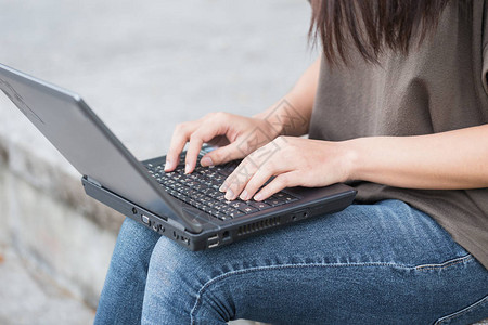 在户外使用笔记本电脑的工作生活方式封闭式商业妇女图片