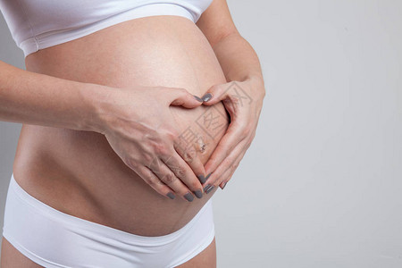 一名孕妇的腹部被白色隔离图片