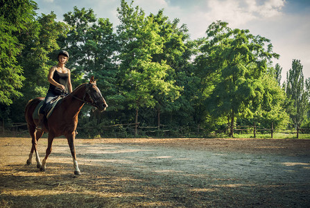 马场上的年轻女孩骑马课图片