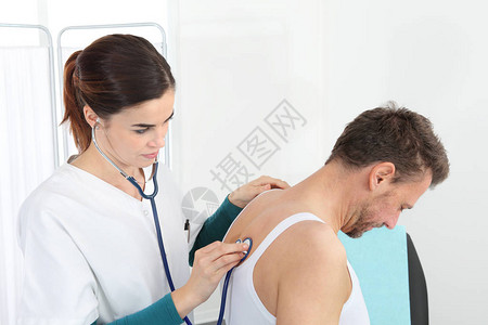 医生在医疗办公室用听诊器对图片