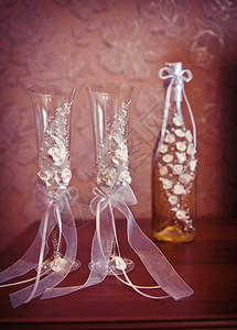 桌上放着两个结婚玻璃杯和一瓶香槟图片