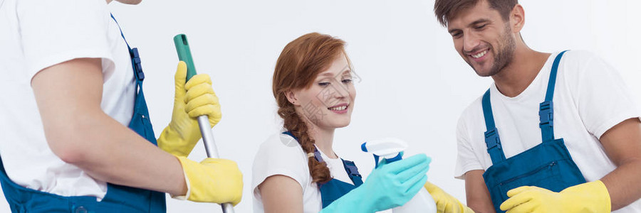 专业女清洁工向同事展示清洁剂图片