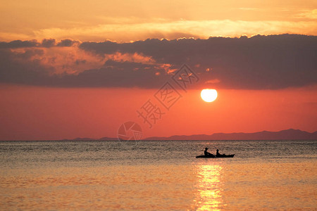 日落时在海上划独木舟图片