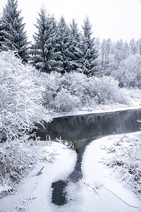 小河周围白雪皑的森林的冬季景观图片