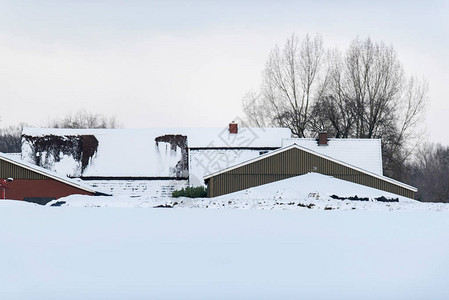在乡村景观中被雪覆盖的房子图片