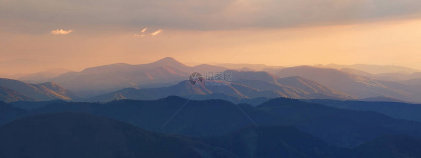 的傍晚阳光照在山顶上朦胧的晚上景观夏季全景背在山的美图片