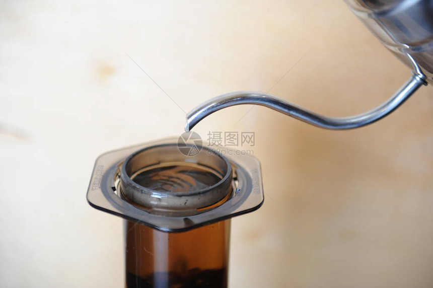 在木制背景上酿造的另类咖啡特色咖啡水流从滴水器中倾图片