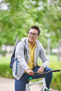 戴眼镜的男子坐在自行车上图片