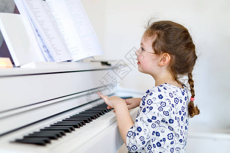 美丽的小女孩在客厅或音乐学校弹钢琴学龄前儿童演奏乐器很开心教图片