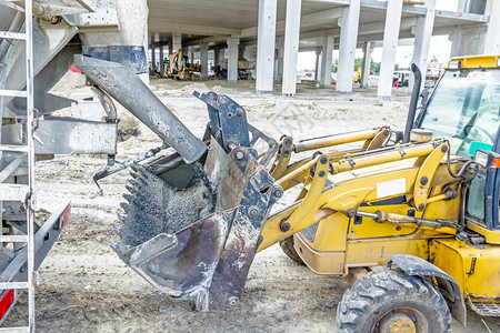 混凝土搅拌车正将新鲜混凝土倒进建筑工背景图片