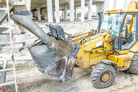 混凝土搅拌车正将新鲜混凝土倒进建筑工背景图片