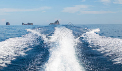 来自高速船只和岛屿背景的海浪图片
