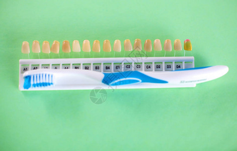 有牙刷的丙烯酸假牙在白色背景图片