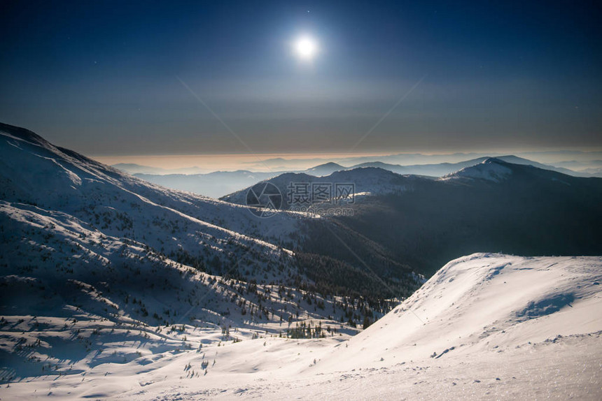 寒冬山脉的分布范围夜晚白雪中夜深蓝天空下图片