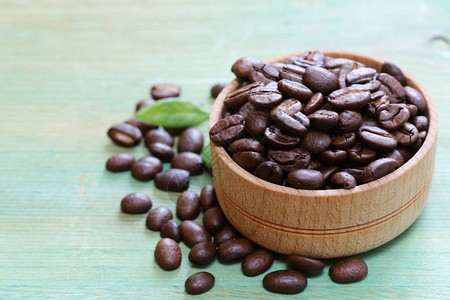 木质背景中的棕色咖啡豆图片