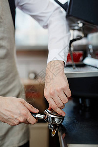 咖啡师在portafilter中研磨咖啡豆图片
