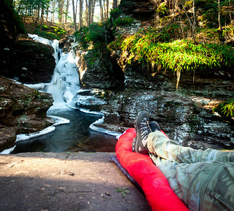 瀑布前睡袋上的徒步旅行者图片
