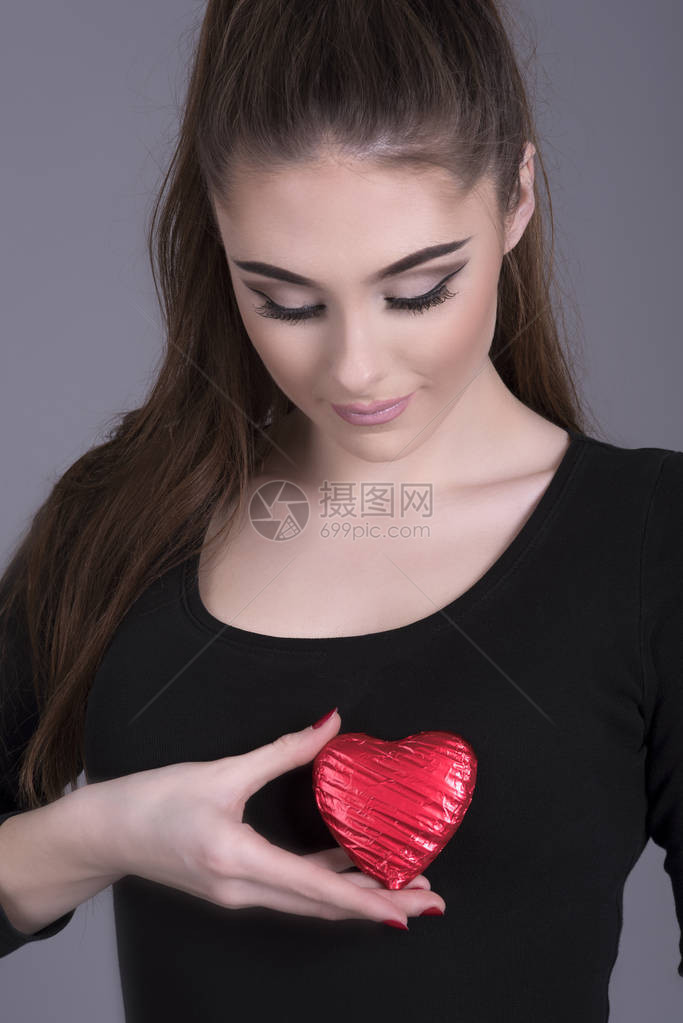 年轻女人的胸背着巧克力心肌图片