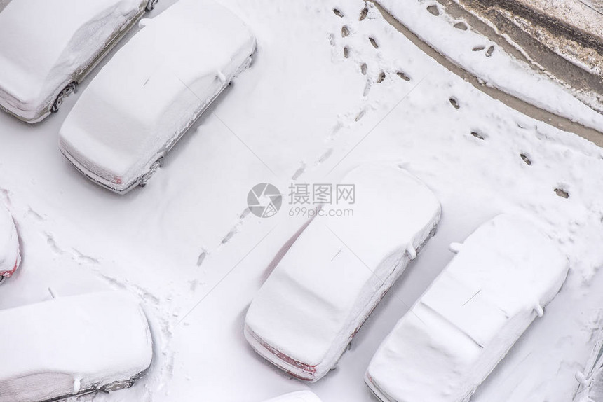 停在被雪覆盖的城市的汽车图片