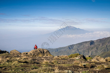男人与手机坐在坦桑尼亚梅鲁山MeruMount图片