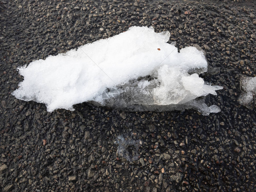 春天柏油街道上融化的雪图片