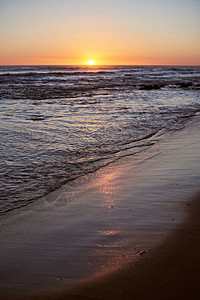 对海滩沙尘垂直方向的日出反光图片