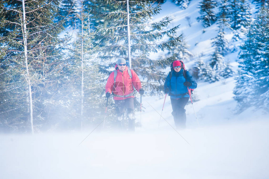 有两个登山者在暴风雪中登山图片