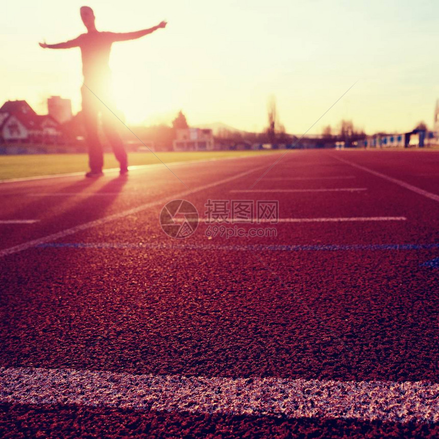 马拉松男子训练日落时在体育场上穿着跑步衣服的运动员体育和健康生活方式概念和慢跑图片