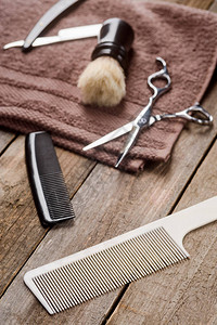 胡子梳剪刀刷子毛巾和木质表面的直图片