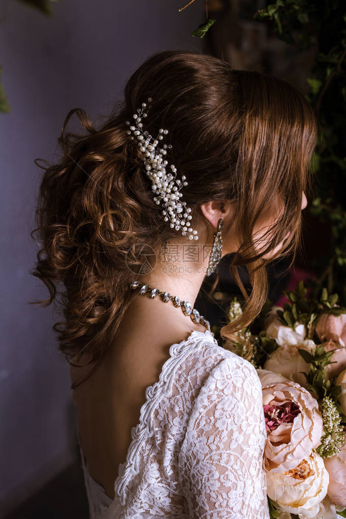 新娘的发型在婚纱礼服与鲜花后视图图片
