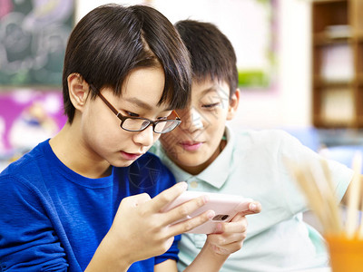 朝鲜语两名亚洲小学男生玩游戏用的手机背景