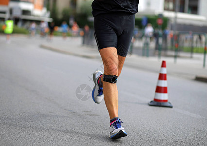在城里马拉松比赛期间运动员用绷带在膝图片